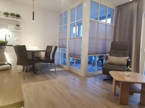 sala de estar con mesa de comedor y sillas en Apartmenthaus Atlantik en Kühlungsborn