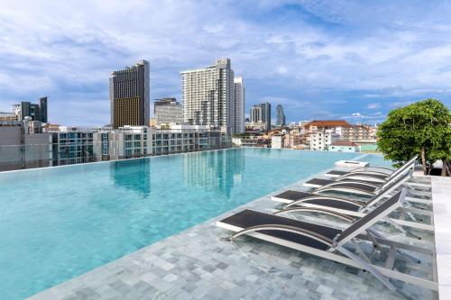 - une piscine sur le toit d'un immeuble avec des chaises longues dans l'établissement Amethyst Hotel Pattaya, à Pattaya