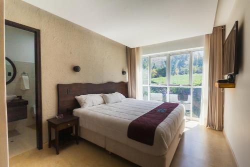 una camera con un letto e una grande finestra di Life Hotel Valle Sagrado a Urubamba