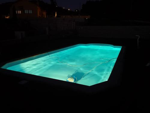 una piscina illuminata di notte di Banana House a Baiona