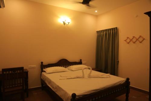 A bed or beds in a room at Ponni Homestay Kumbakonam