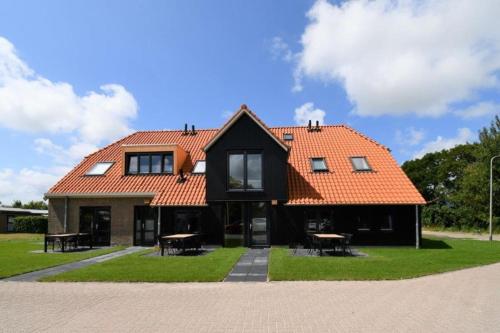 a house with an orange roof and some tables at Skylgerduin in Midsland