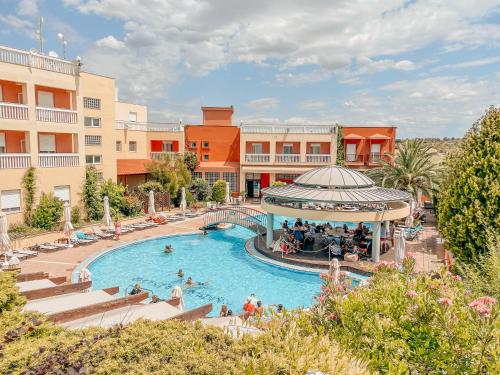 a pool at a resort with people in it at Ambassador Hotel Thessaloniki in Plagiárion