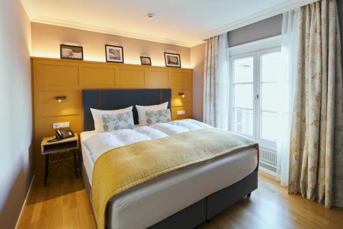 a bedroom with a large bed and a window at Boutique Hotel Orangerie in Düsseldorf