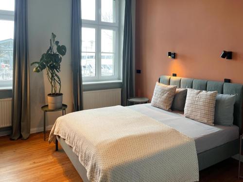 una camera con un letto in una stanza con finestre di Apartments am Hafen a Stralsund