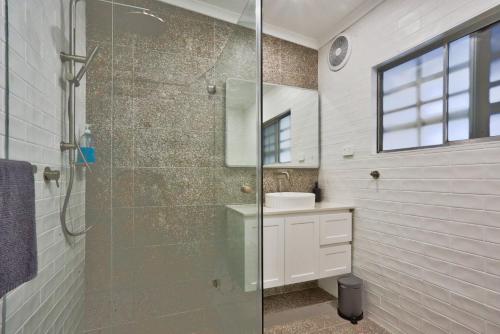 ein Bad mit einer Glasdusche und einem Waschbecken in der Unterkunft 2 Bedroom House with 2 E-Bikes Included at Centre of Chippendale in Sydney