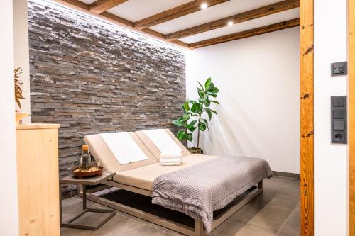 a bed in a room with a brick wall at Turracher Zirbenlodges in Turracher Hohe