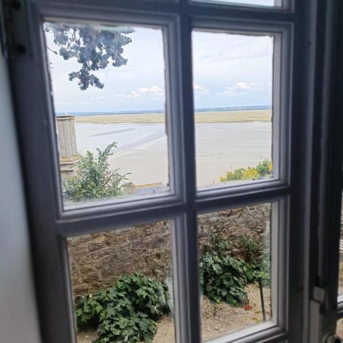 d'une fenêtre avec vue sur un champ. dans l'établissement Chez Adèle, au Mont-Saint-Michel