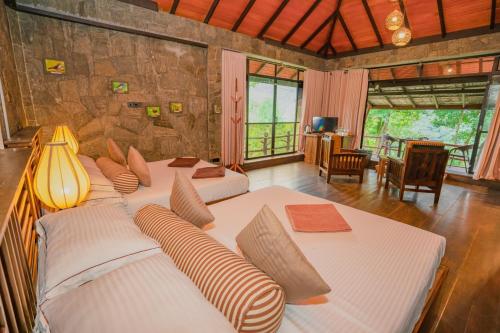 a bedroom with three beds and a living room at The Tea Cottage Resort & Spa in Nawalapitiya