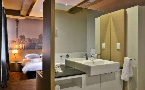 La salle de bains est pourvue d'un lavabo et d'un lit. dans l'établissement Reef Hotel, à Johannesbourg