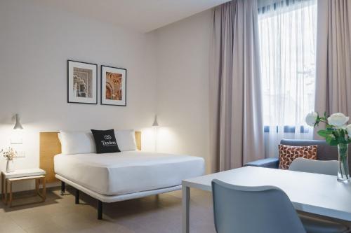 Habitación de hotel con cama y mesa en Tandem Torre de la Calahorra en Córdoba