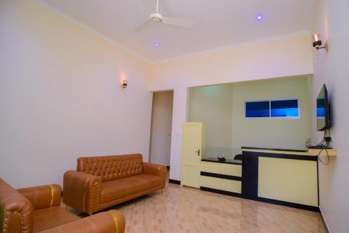 een woonkamer met een bank en een televisie bij Paco Lodge in Dodoma