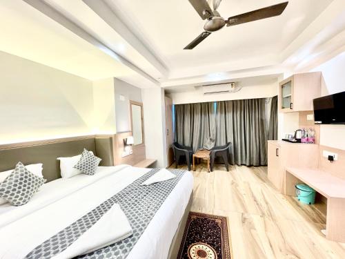 a hotel room with a bed and a desk at HOTEL G RESORT ! PURI Swimming-pool-and-Garden, near-sea-beach-and-temple fully-air-conditioned-hotel with-lift-and parking-facility, Breakfast included, best hotel in puri - 2 in Puri