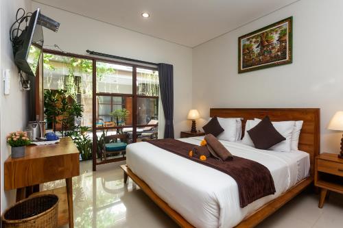 ein Schlafzimmer mit einem großen Bett und einem Balkon in der Unterkunft Naksa Homestay Sanur in Sanur