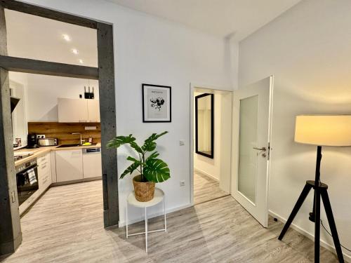 uma sala de estar com um vaso de plantas sobre uma mesa em MEINpartments - Modern Business Apartment em Wolfsburg