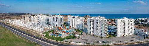 una vista aérea de una ciudad con edificios blancos y el océano en Caesar Blue Seaside Luxury Apartments en Kalecik