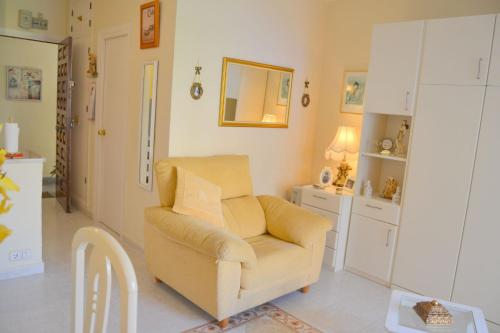 a living room with a chair and a mirror at Los Horizontes No70 in Benalmádena