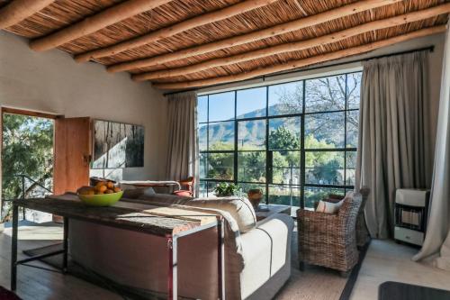 sala de estar con cama y ventana grande en The Whyte House en Graaff-Reinet