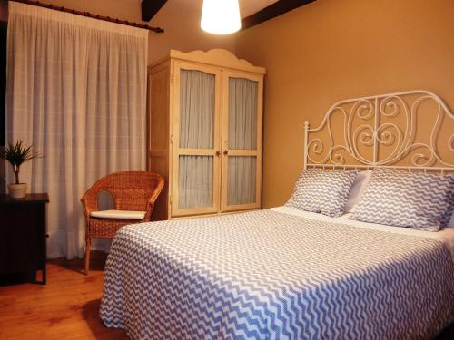 um quarto com uma cama com um cobertor azul e branco em Casa Cotiellu em Llanes