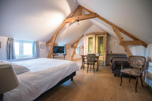 - une chambre mansardée avec un lit et un bureau dans l'établissement B&B Le Vieux Marronnier, à Foy-Notre-Dame