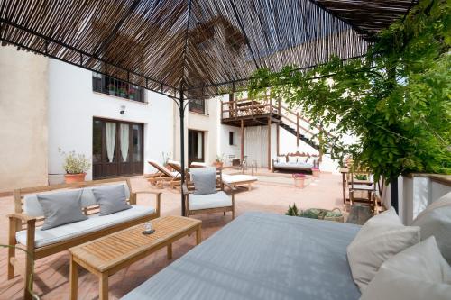 une terrasse avec un lit et des chaises dans l'établissement Casa Bombo, à Grenade