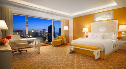 - une chambre d'hôtel avec un lit et un bureau dans l'établissement Wynn Palace, à Macao