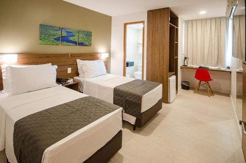 ein Hotelzimmer mit 2 Betten und einem Bad in der Unterkunft Bristol Umarizal Belem in Belém