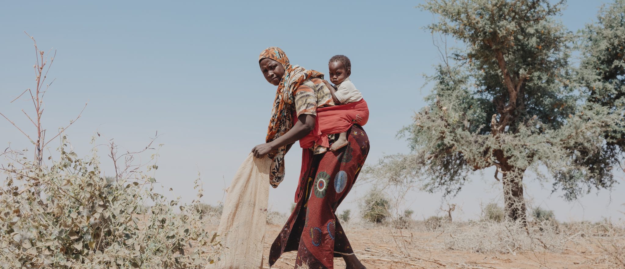 Nigerian woman and her daughter prepare a field for rainy season