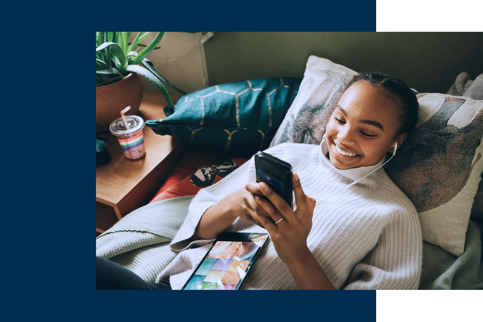 Gen Z student browsing on her phone, lying on a bed