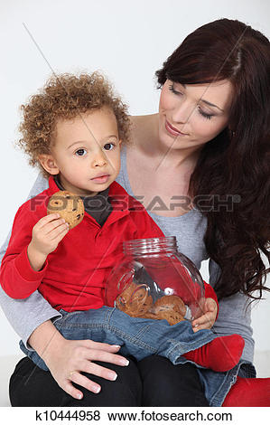 Pictures of Cute child eating cookies on his mother's lap.