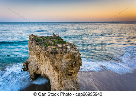 Stock Photo of Sea stack and waves in the Pacific Ocean at sunset.