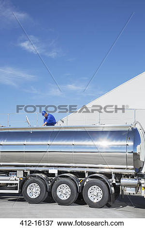 Picture of Worker on platform above stainless steel milk tanker.