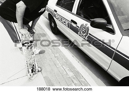 Pictures of Young man with skateboard leaning into police car.