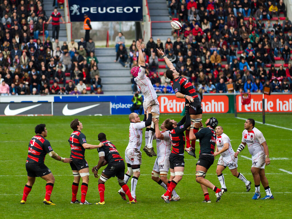 The image shows an example of marketing. The advertising boards of Nike and Peugeot are seen behind the players.