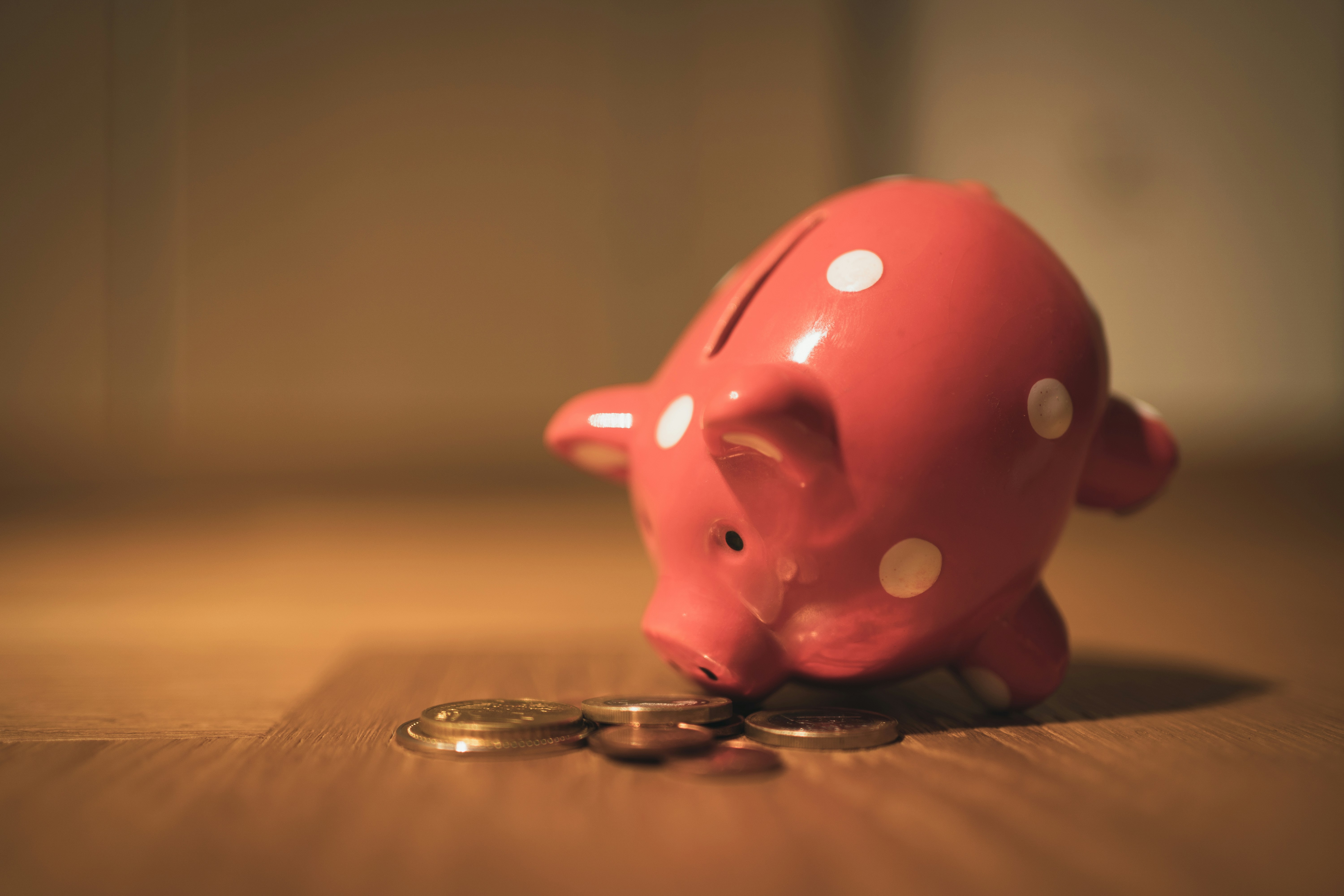 Pink piggy bank train got eat gold coins on a wooden table