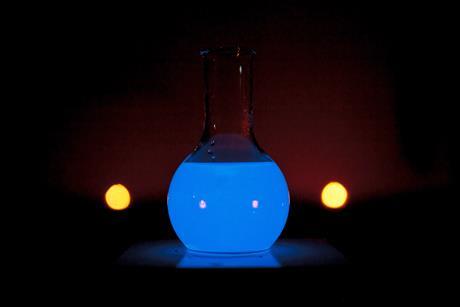 A round glass flask glowing blue