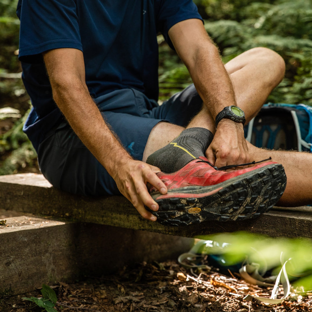 Hiker about to pull off his shoes, cause his socks aren't smelly