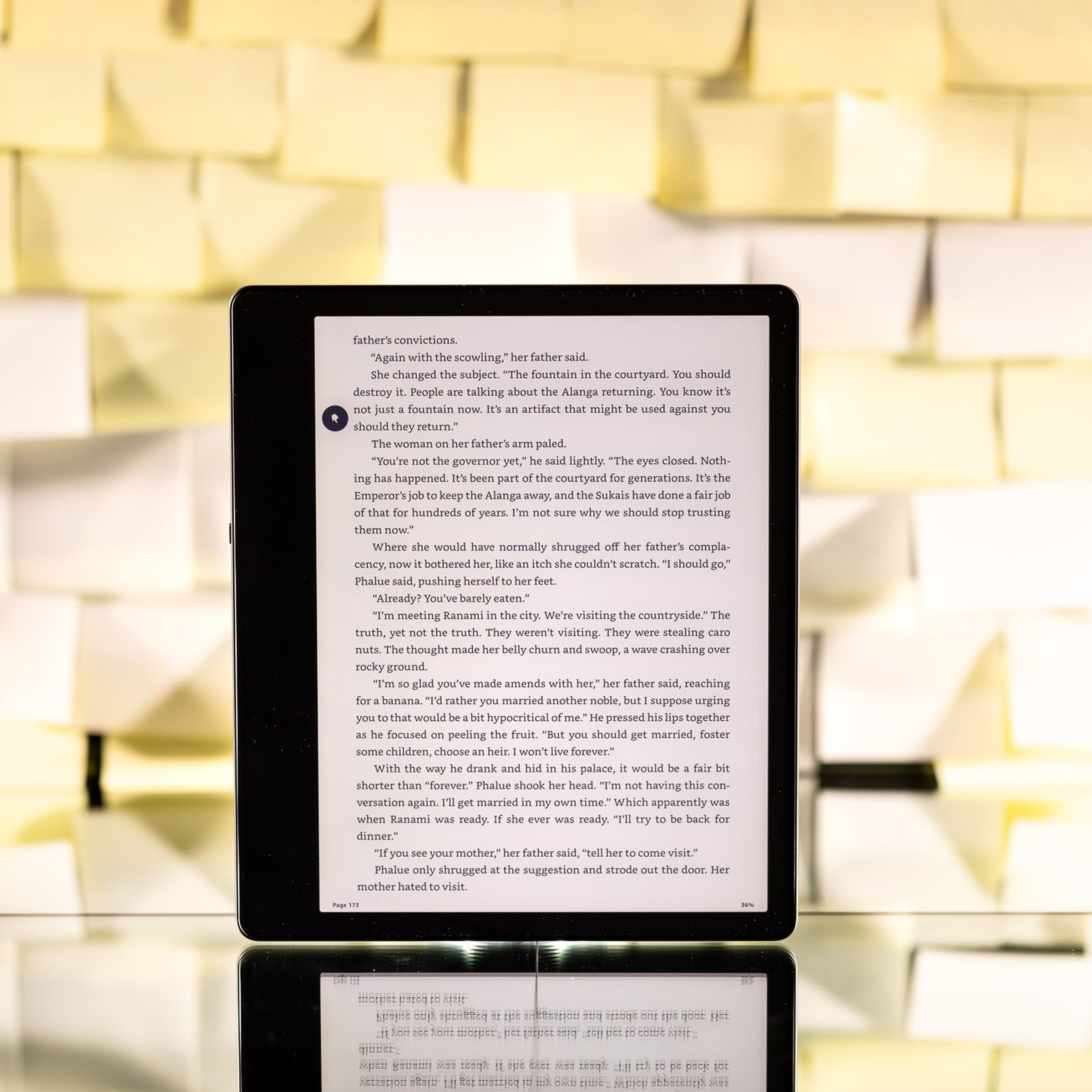 The Kindle Paperwhite standing upright in front of a background of yellow post-it notes.