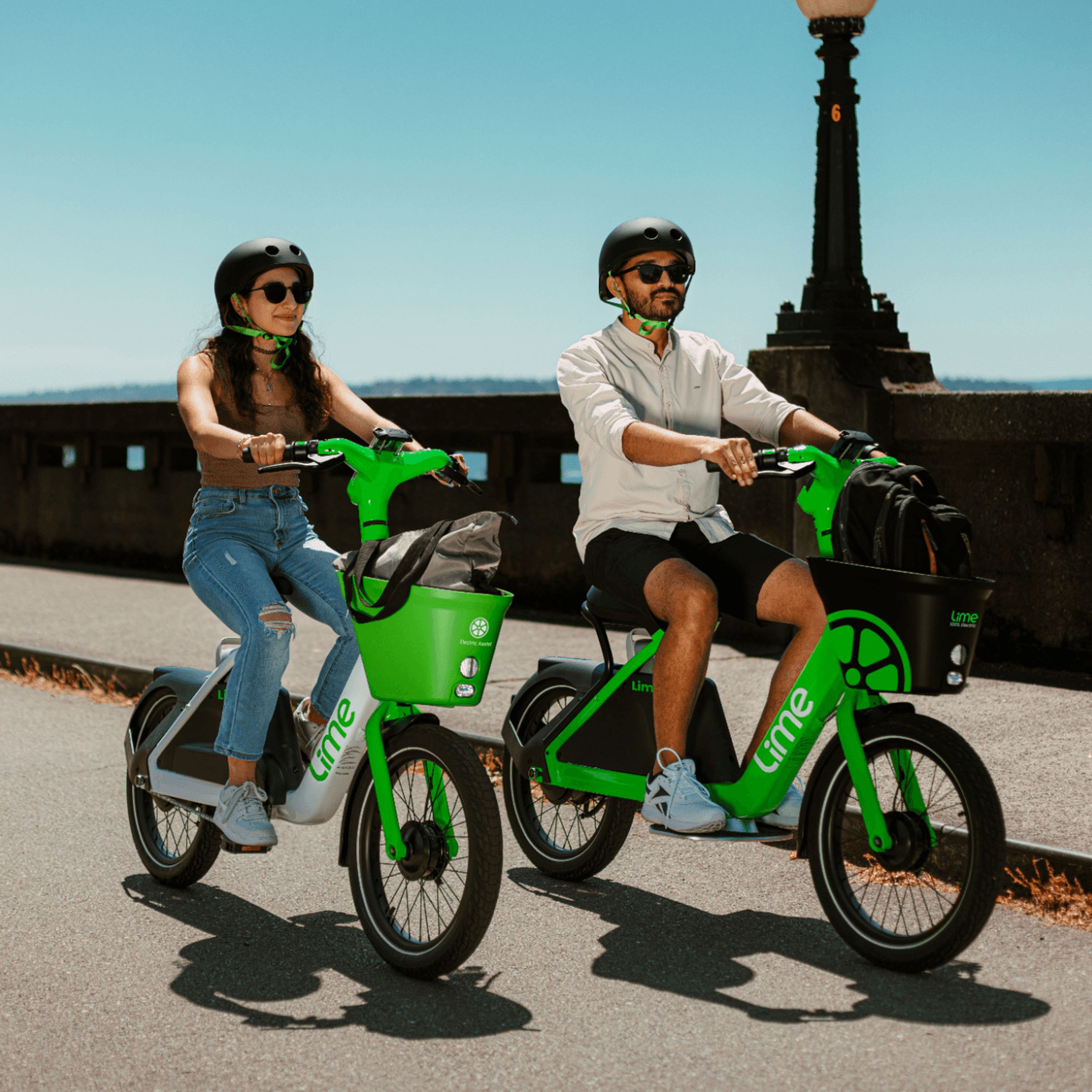 A photo showing two people riding a LimeBike and LimeGlider