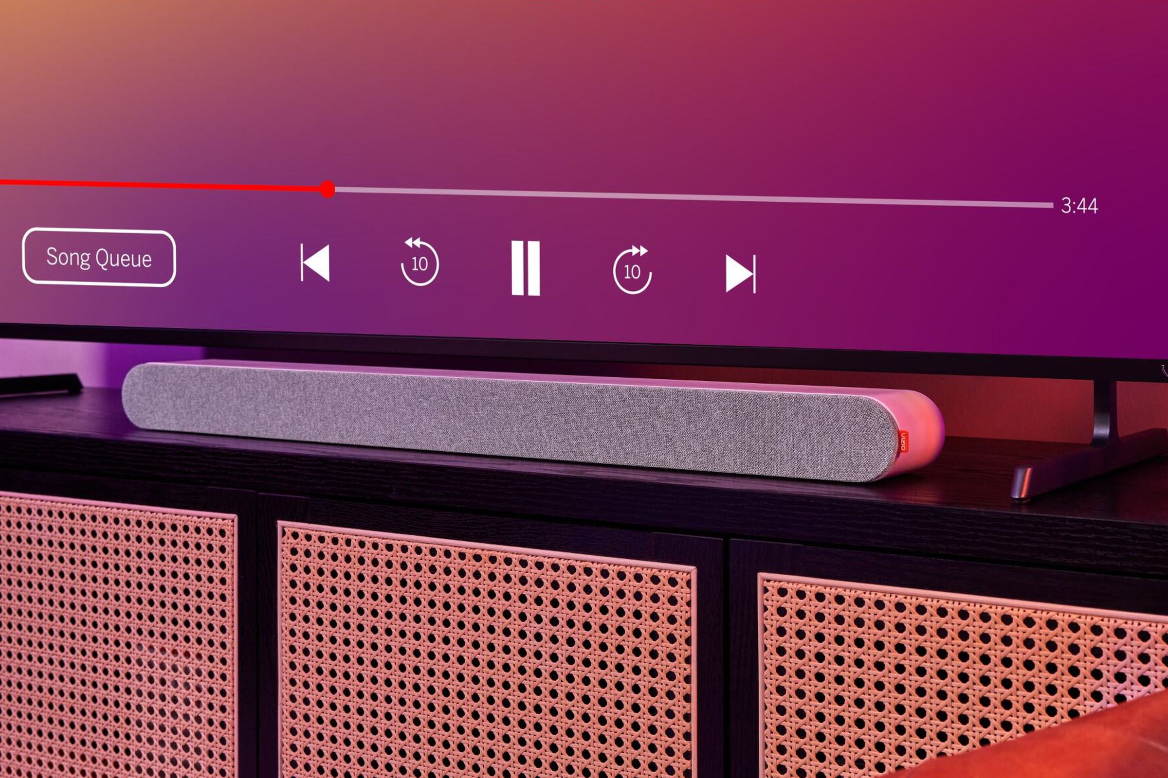 A picture of the Vizio MicMe Soundbar sitting in front of a TV, both on a piece of furniture.