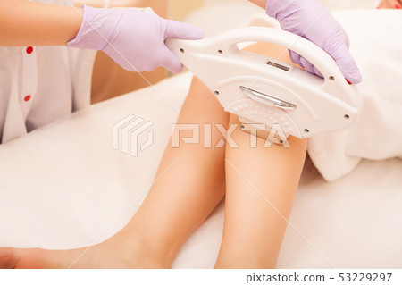 Skin Care. Hair removal on the legs, laser procedure at clinic. Beautician removes hair on beautiful 53229297