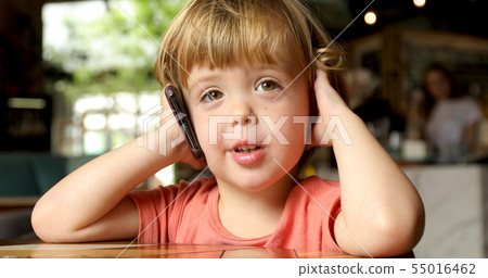 Cheerful toddler speaking on mobile phone 55016462