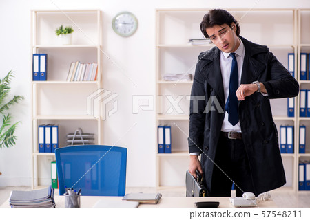 Young male employee in the office in time management concept 57548211