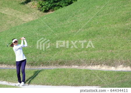 Image of a woman hitting the approach from the rough 64434411