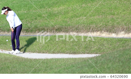 Image of a woman hitting the approach from the rough 64320690