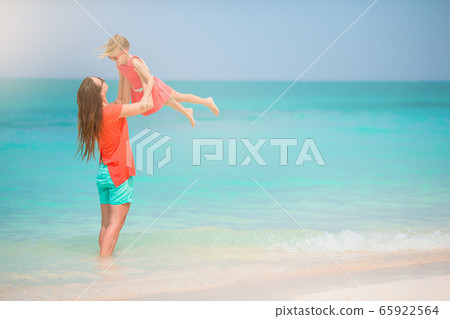 Beautiful mother and daughter on the beach enjoying summer vacation 65922564