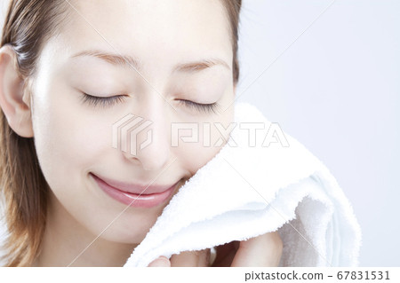 A woman wiping his face with a towel 67831531