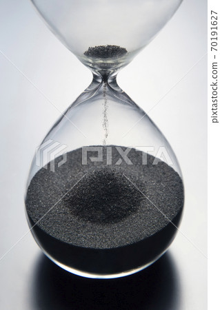 Hourglass on a light background. Time is money. Business solutions in time. 70191627