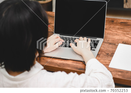 A woman using a laptop computer 70352253