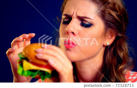 Woman eating hamburger. Appetizing face of girl happy eat junk . 72328713